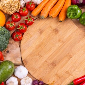 Discover a vibrant assortment of fresh fruits and vegetables arranged on a wooden board. Perfect for healthy eating inspiration.