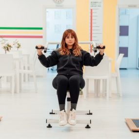A woman exercises in a bright rehabilitation center, focusing on recovery and wellness.